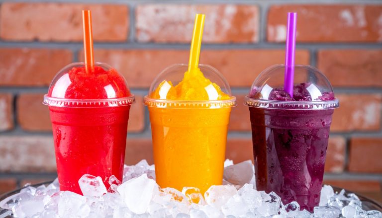 Three,Vibrant,Frozen,Fruit,Slushies,In,Plastic,Cups,With,Straws,